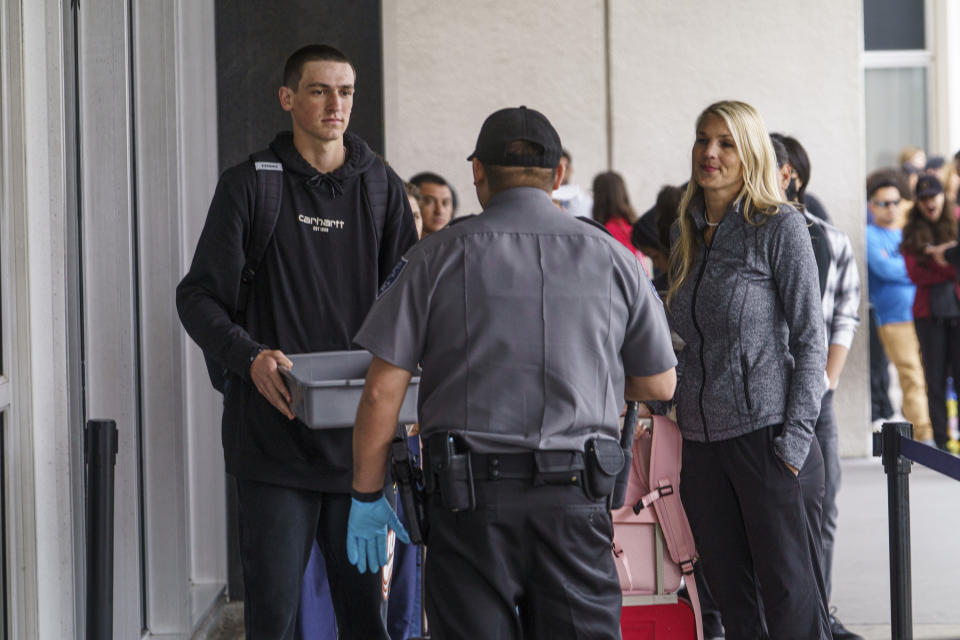 Marni Larsen and her son, Damon Rasmussen of Holladay, Utah, are questioned by a security guard outside the Los Angeles Passport Agency at the Federal Building in Los Angeles on Wednesday, June 14, 2023. Larsen applied for her son's passport two months earlier and spent weeks checking for updates online or through a frustrating call system. (AP Photo/Damian Dovarganes)