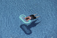 A tourist relaxes in a swimming pool at a hotel in Antalya, southern Turkey, Saturday, June 19, 2021. Hotels in Turkey's Antalya region, a destination beloved by holidaymakers, are preparing to finally resume operations as they expect the return of international tourists after months of setbacks caused by the pandemic that halted travel. (AP Photo/Emrah Gurel)