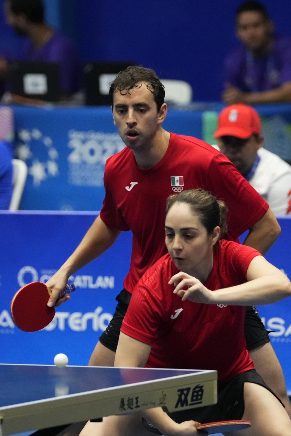 Los mexicanos Yadira Silva y Marcos Madrid disputan la semifinal de dobles mixtos del tenis de mesa el sábado 24 de junio de 2023, en los Juegos Centroamericanos y del Caribe en San Salvador (AP Foto/Arnulfo Franco)