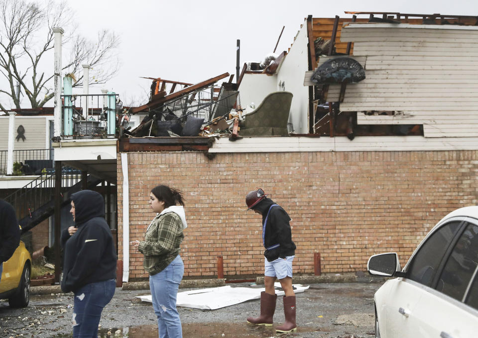 Residents walk past their damaged apartment complex after a storm system swept through Deer Park, Texas (Elizabeth Conley / Houston Chronicle via AP )