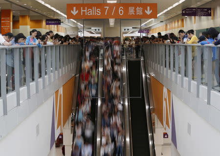 Students descend on escalators to take part in SAT examinations at Asia-World Expo near Hong Kong Airport in Hong Kong, China October 3, 2015. REUTERS/Bobby Yip