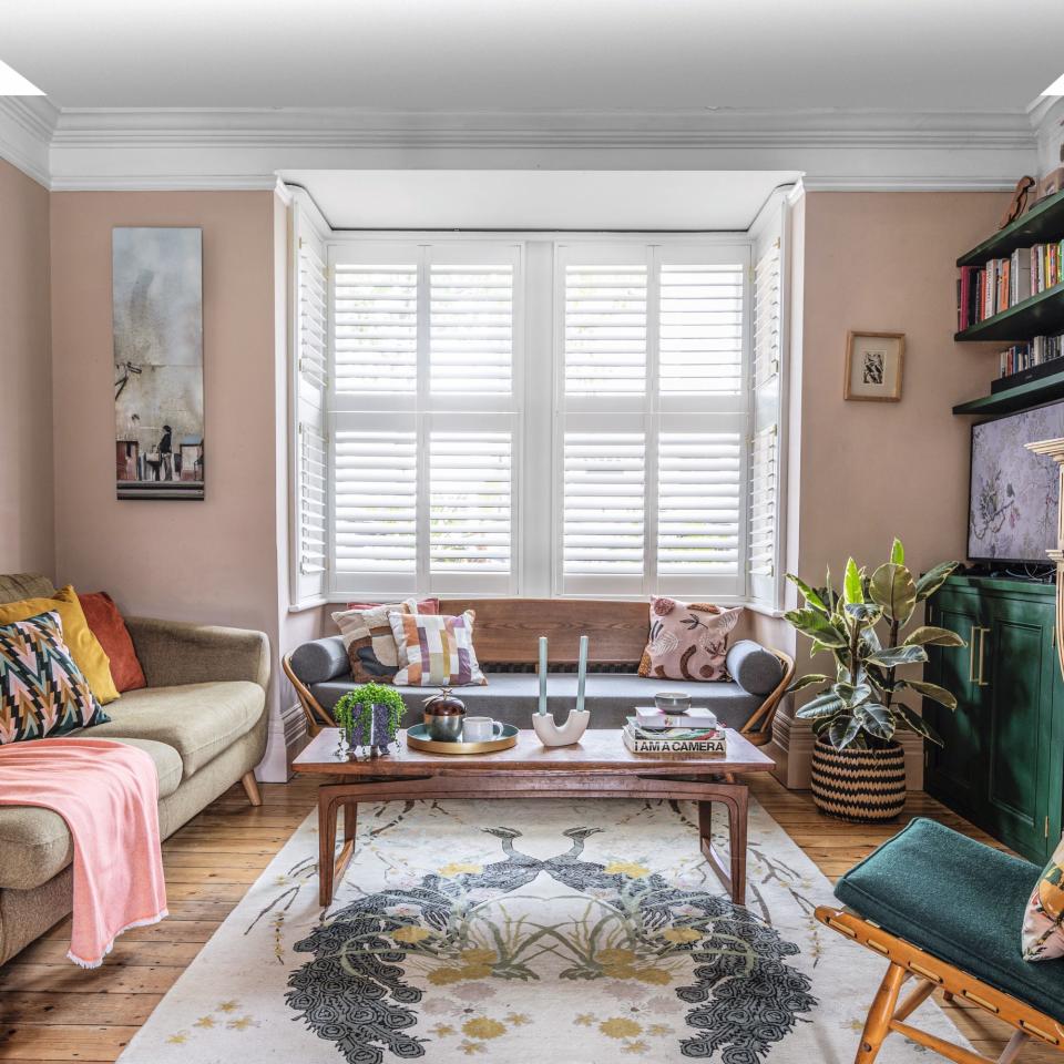 living room with shuttered window, patterned rug and coffee table