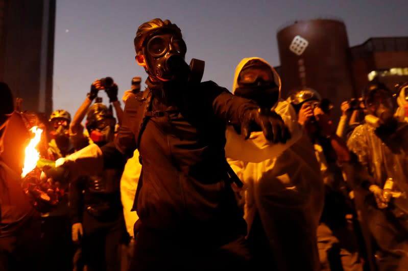 An anti-government protester throws a molotov cocktail during clashes with police, outside Hong Kong Polytechnic University