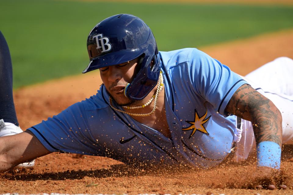 Tampa Bay Rays' Jose Siri slides safely back to first base on a pick-off attempt during the third inning of a spring training baseball game against the New York Yankees, Tuesday, Feb. 28, 2023, in Kissimmee, Fla. (AP Photo/Phelan M. Ebenhack)