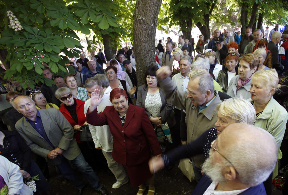 People shout slogans during a commemoration service of four people killed during clashes last week between Ukrainian and pre-Russian forces, in the centre of Slovyansk, eastern Ukraine, Wednesday, May 7, 2014. The U.S. and European nations have increased diplomatic efforts ahead of Ukraine's May 25 presidential election, as a pro-Russian insurgency continues to rock the country's eastern regions. (AP Photo/Darko Vojinovic)