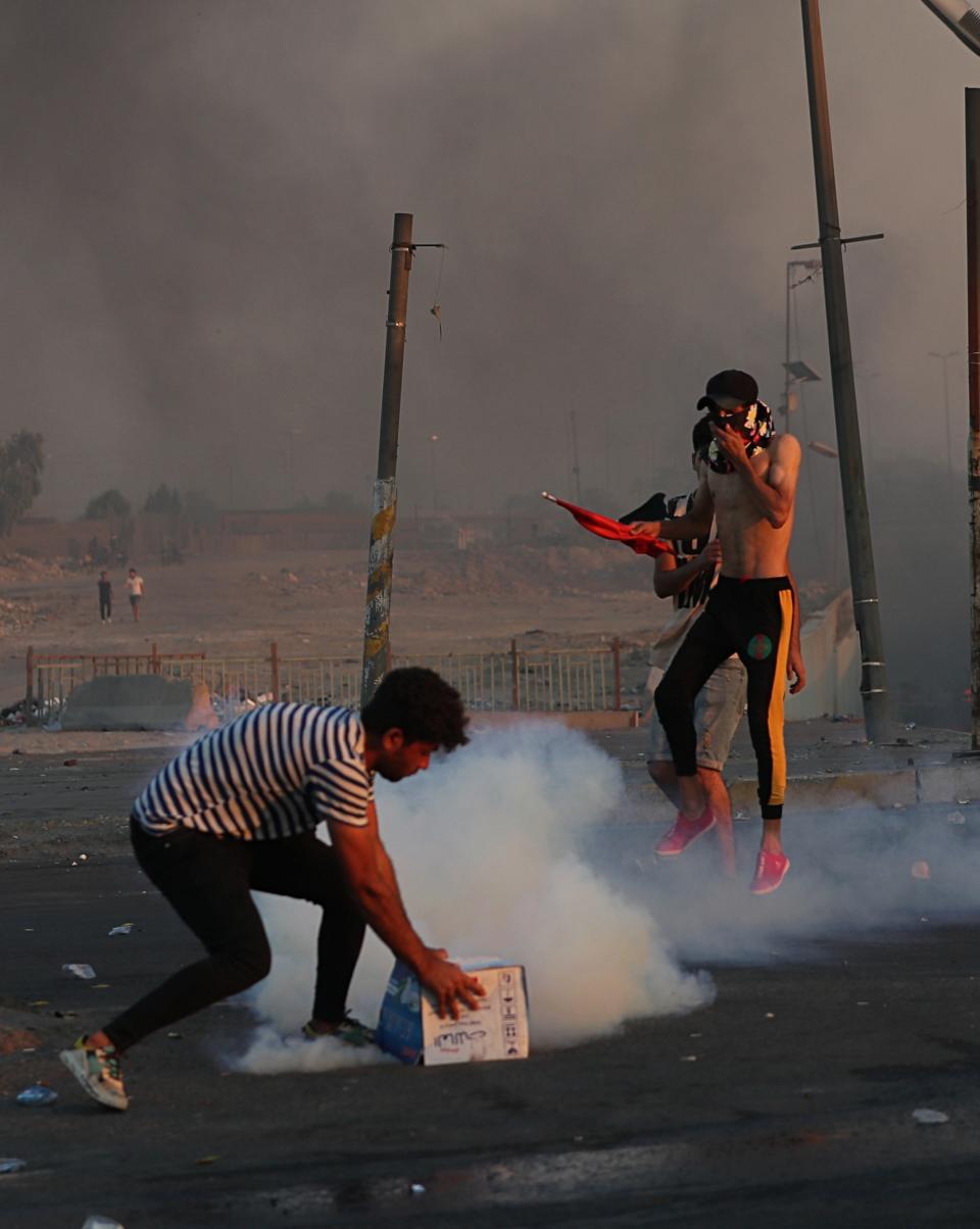 Iraqi security forces fire tear gas to disperse anti-government protesters during a demonstration in Baghdad, Iraq, Saturday, Oct. 5, 2019. Iraqi protesters pressed on with angry anti-government rallies across several provinces, in some cases torching party offices, for the fifth day, ignoring appeals for calm from political and religious leaders. Security agencies kept up their heavy crackdown, firing live ammunition and killing more than 14 protesters Saturday. (AP Photo/Hadi Mizban)