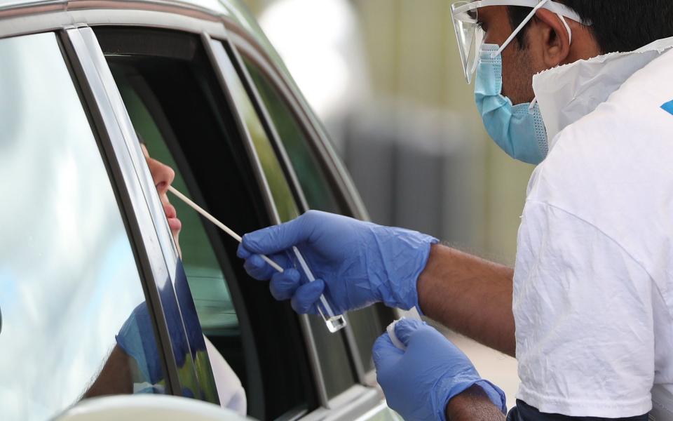 A man is tested at a drive-through testing facility for Covid-19 at Edinburgh Airport - PA