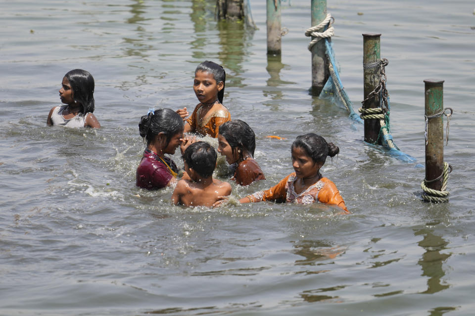 FILE - Children cool themselves in the river Gomati as northern Indian continues to reel under intense heat wave in Lucknow in the the Indian state of Uttar Pradesh, April 19, 2023. A searing heat wave in parts of southern Asia in April this year was made at least 30 times more likely by climate change, according to a rapid study by international scientists released Wednesday, May 17. (AP Photo/Rajesh Kumar Singh, File)