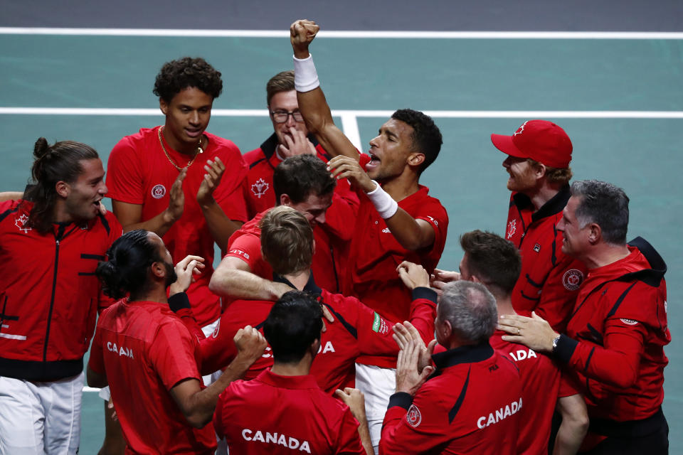 Canada's Felix Auger Aliassime, center, celebrates with teammate after defeating Australia's Alex de Minaur during the final Davis Cup tennis match between Australia and Canada in Malaga, Spain, Sunday, Nov. 27, 2022. (AP Photo/Joan Monfort)