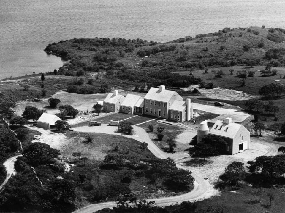 Workmen and gardeners putting the finishing touches on the new home of Jackie Onassis in Martha's Vineyard.