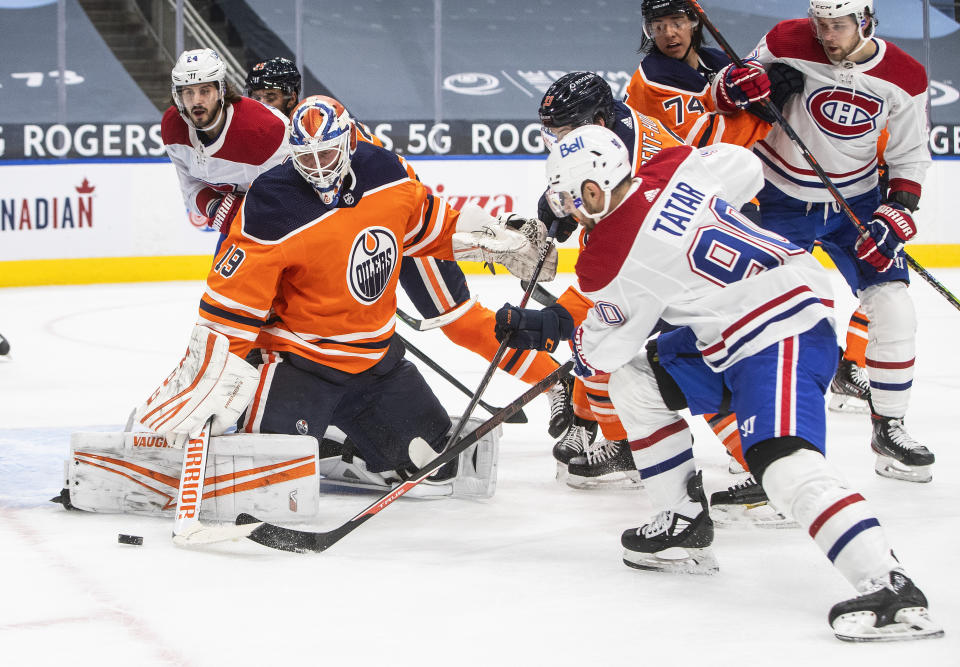 Edmonton Oilers goalie Mikko Koskinen (19) makes a save against Montreal Canadiens' Tomas Tatar (90) during first-period NHL hockey game action in Edmonton, Alberta, Saturday, Jan. 16, 2021. (Jason Franson/The Canadian Press via AP)