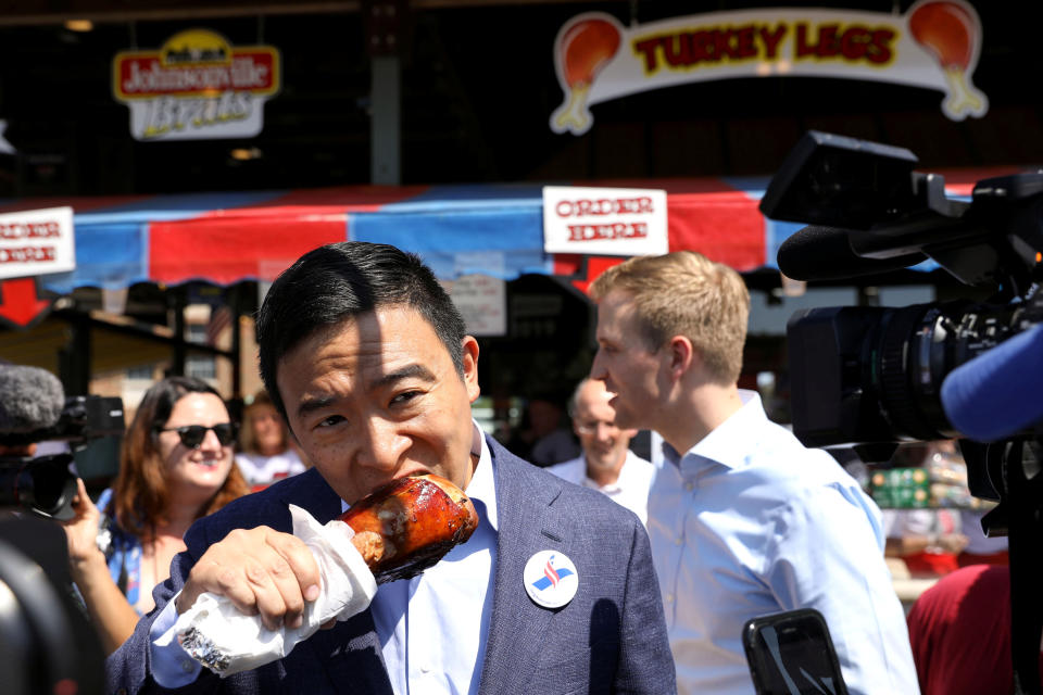 Former technology entrepreneur Yang eats a turkey leg at the Iowa State Fair in Des Moines on Aug. 9. A stop at the state fair -- and samplings of its fare -- is a virtual must for White House aspirants in the walk-up to the Iowa caucuses that start the balloting in each presidential campaign cycle.