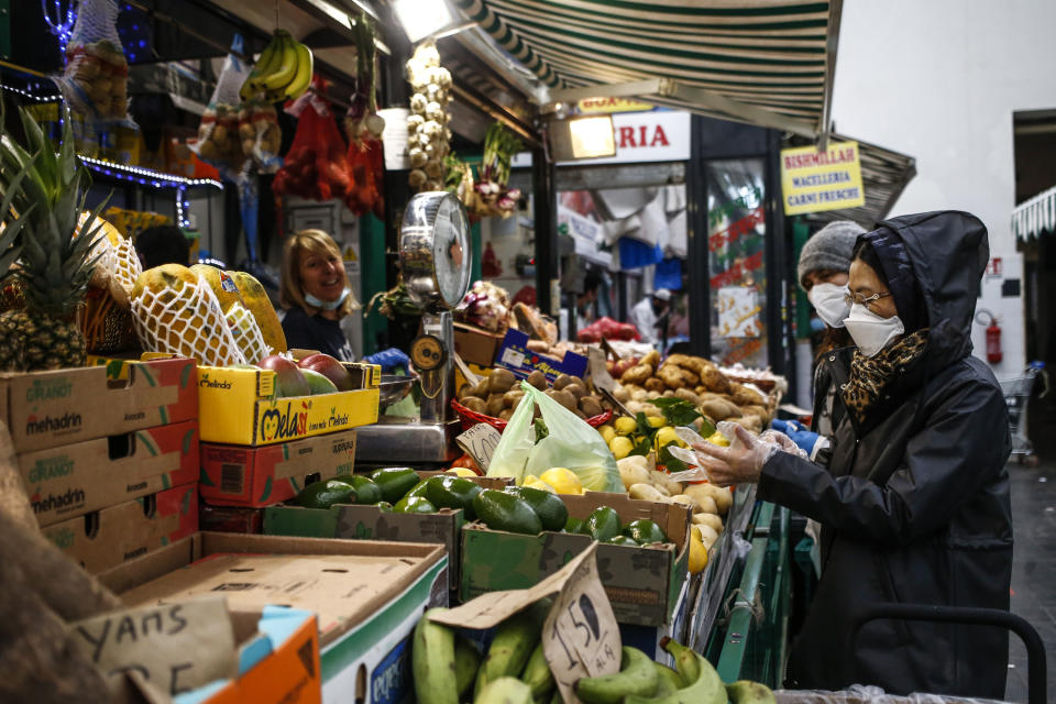 People shop in a covered market in downtown Rome Friday, April 17, 2020. Covered markets were among the activities that were allowed to continue working open during the coronavirus outbreak in Italy. (Cecilia Fabiano/LaPresse via AP)