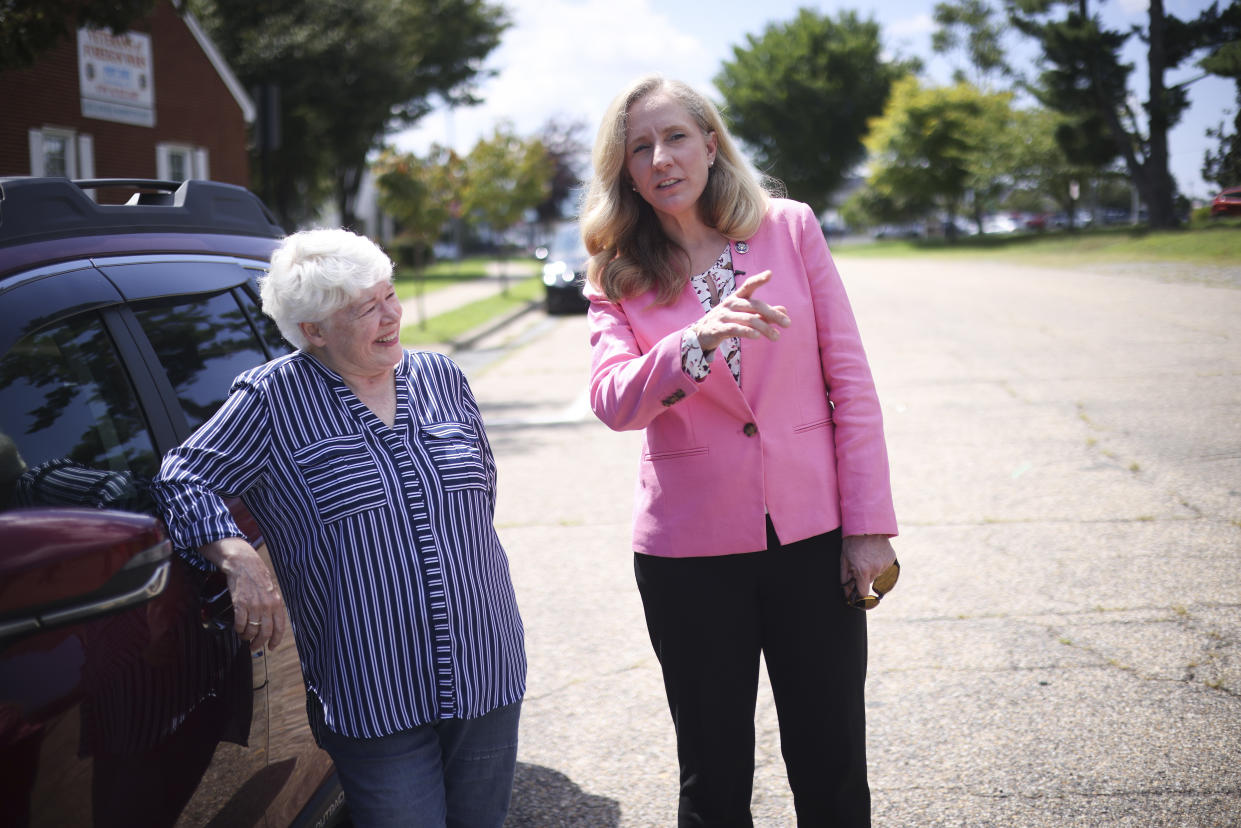 Rep. Abigail Spanberger and a woman leaning on a vehicle.