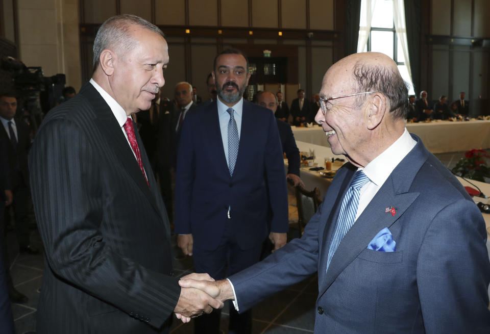 Turkey's President Recep Tayyip Erdogan, left, greets U.S. Commerce Secretary Wilbur Ross at his palace, in Ankara, Turkey, Tuesday, Sept. 10, 2019. Turkey accused the United States on Tuesday of taking only "cosmetic steps" toward the creation of a so-called "safe zone" in northeast Syria and renewed Ankara's threat of unilateral military intervention to form a buffer area along its border.(Presidential Press Service via AP, Pool)