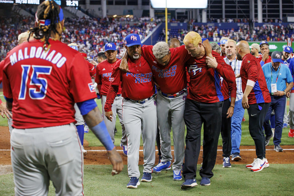 Puerto Rico pitcher Edwin Diaz (39) is helped by team pitching coach Ricky Bones and medical staff after a World Baseball Classic game against the Dominican Republic, Wednesday, March 15, 2023, in Miami. (David Santiago/Miami Herald via AP)