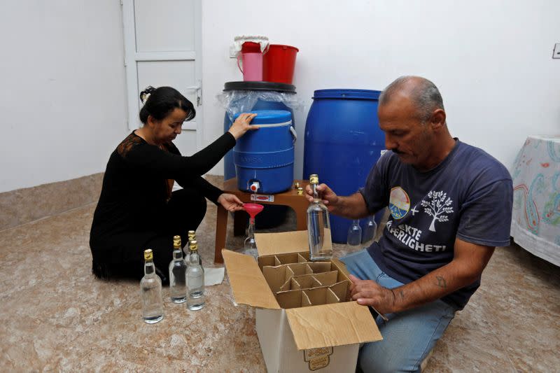 Saad Hussein an Iraqi Yazidi, packs bottles of Arak into boxes which is produced out of dates, on the outskirts of Mosul