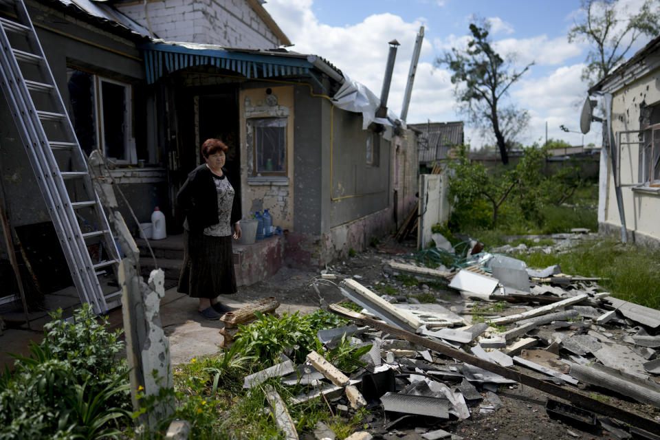 Nataliia Fedorova stands outside her home ruined by attacks, in Irpin, on the outskirts of Kyiv, Ukraine, Thursday, May 26, 2022.(AP Photo/Natacha Pisarenko)