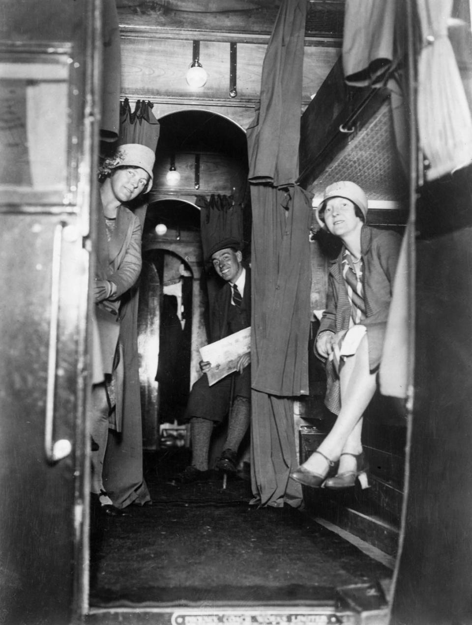 <p>English commuters sit in their bunks while on-board an overnight train.</p>