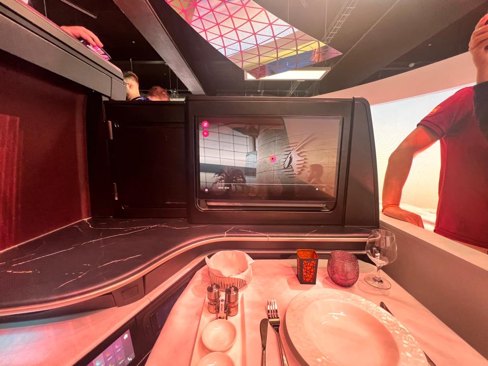 A first-person view of the face-to-face seating configuration with privacy divider of QSuite Next Gen at the 2024 Farnborough Airshow