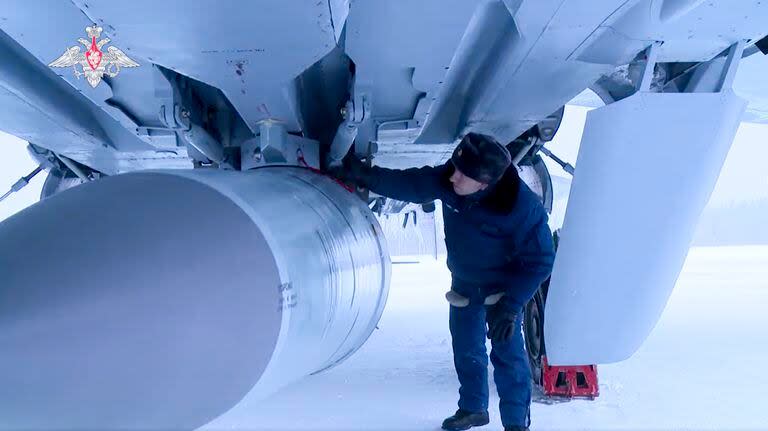 En esta foto tomada de un video proporcionado por el Servicio de Prensa del Ministerio de Defensa de Rusia el sábado 19 de febrero de 2022, un técnico militar ruso verifica un caza MiG-31K de la Fuerza Aérea rusa que transporta un misil de crucero hipersónico Kinzhal estacionado en un campo de aviación durante maniobras militares. 