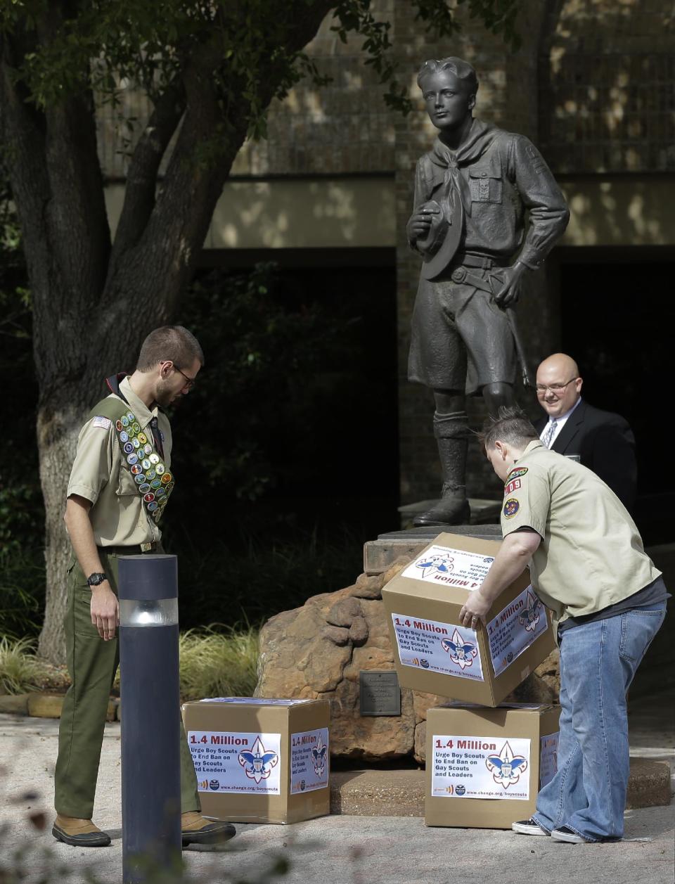 FILE - In this Feb. 4, 2013 fill photo Eagle Scout Will Oliver, Duxbury, Mass., left, and former den leader Jennifer Tyrrell of Bridgeport, Ohio, place boxes filled with a petition urging the Boy Scouts of America to end a policy banning gay scouts in front of the BAS headquarters in Dallas, Texas. The BSA said Wednesday, Feb. 12, 2014 that it lost 6 percent of its membership after an often-bruising year in which it announced it would accept openly gay boys for the first time, over the objections of some participants who eventually left the organization. (AP Photo/Tony Gutierrez, File)