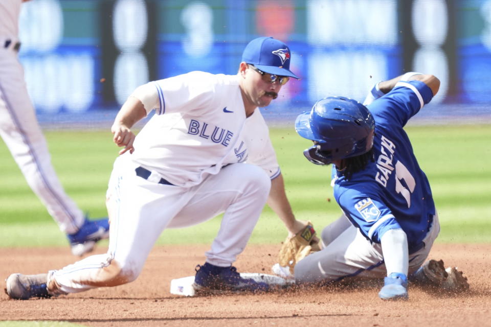 Toronto Blue Jays second baseman Davis Schneider tags out Kansas City Royals third baseman Maikel Garcia on a steal attempt during the sixth inning of a baseball game in Toronto on Sunday, Sept. 10, 2023. (Nathan Denette/The Canadian Press via AP)