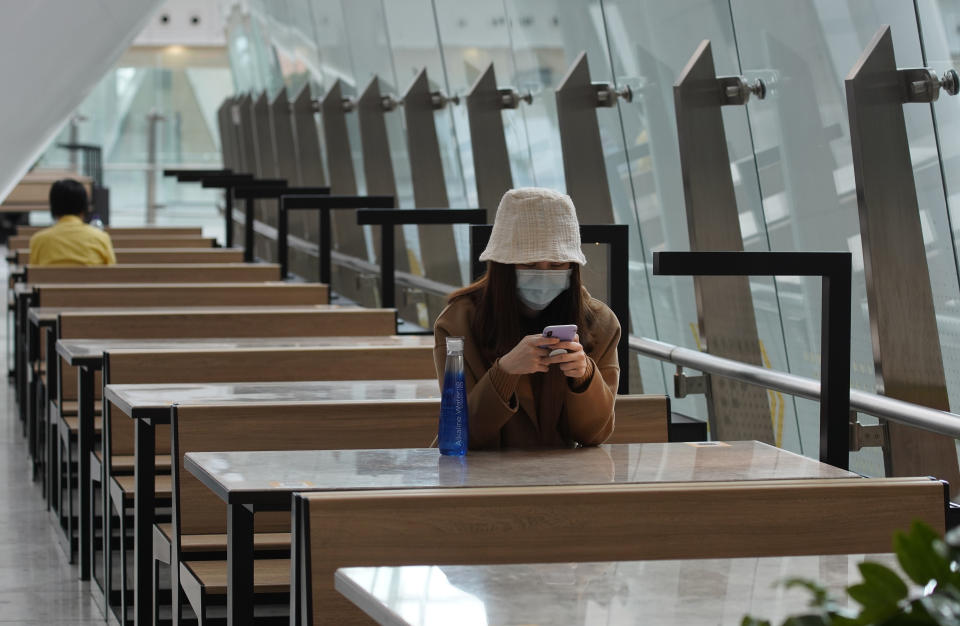 A woman wears protective face mask at the high speed train station in Hong Kong, Tuesday, Jan. 28, 2020. Hong Kong's leader has announced that all rail links to mainland China will be cut starting Friday as fears grow about the spread of a new virus. (AP Photo/Vincent Yu)