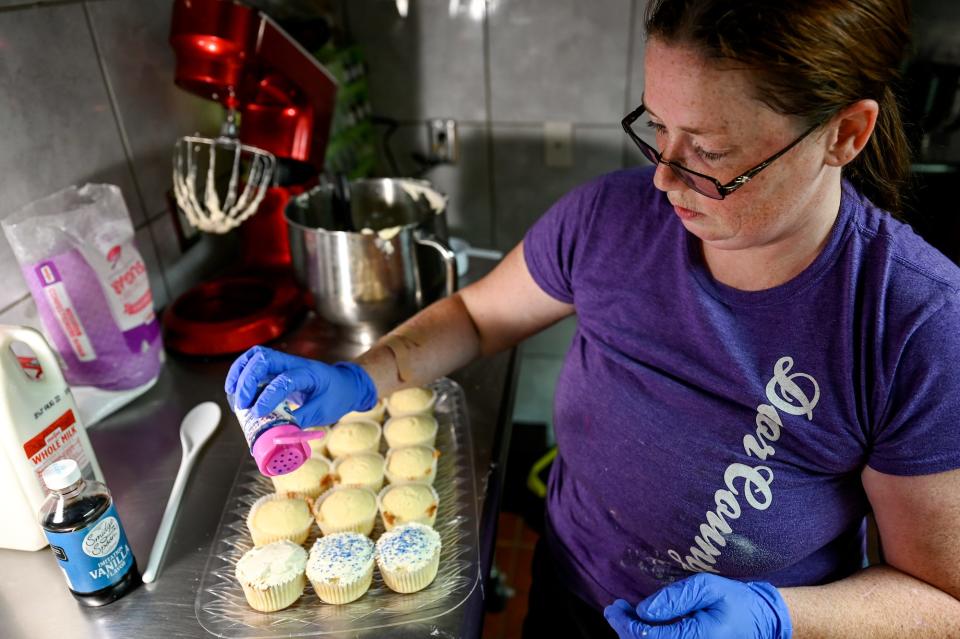 Jenniffer Reaser, owner of Delicious Delights Cakes, decorates cupcakes on Friday, Aug. 3, 2022, at her bakery at the Lansing Mall.