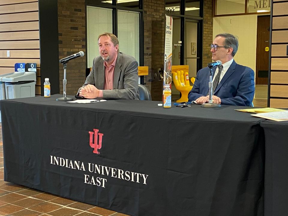 Kyle Anderson, a clinical assistant professor of business economics at the Kelley School of Business in Indianapolis, speaks Wednesday during the Business Outlook Panel at Indiana University East. •	Russell Rhoads, an associate clinical professor of financial management at the Kelley School of Business, listens.