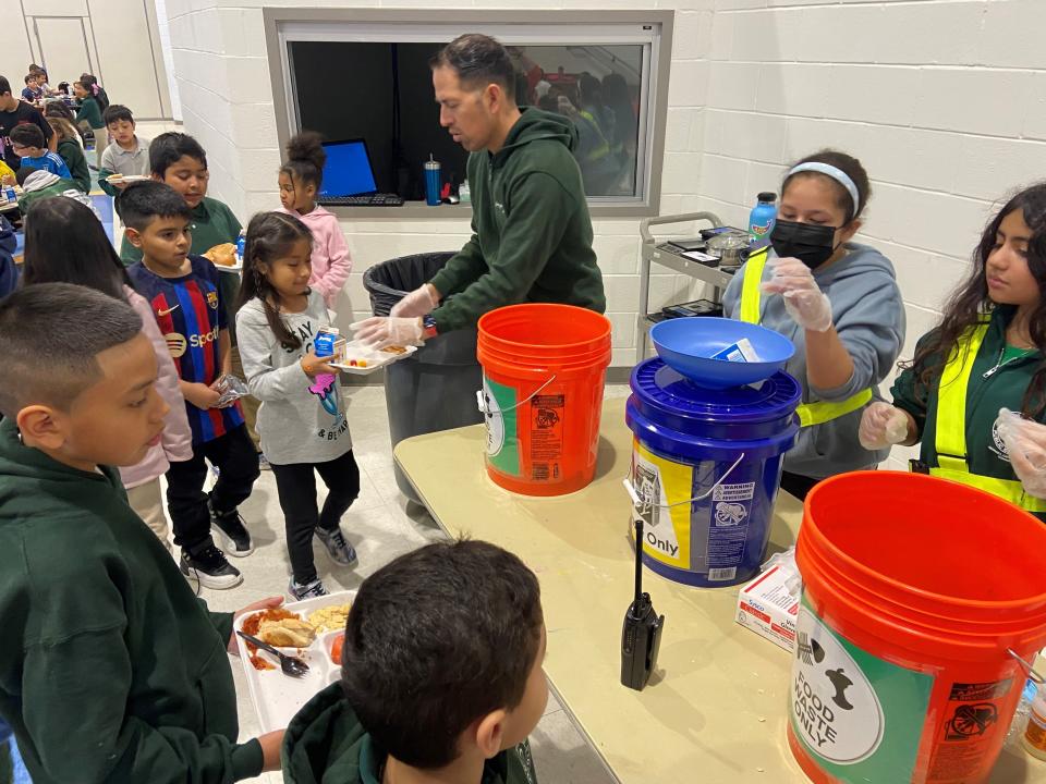 Students at George L. Catrambone Elementary School sort food scraps from lunch to into the composter.