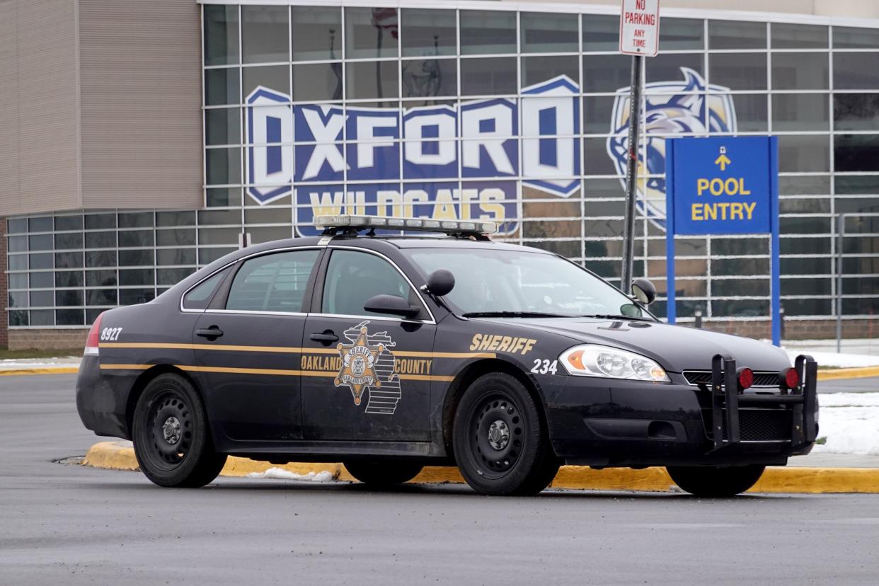 A police vehicle remains parked outside of Oxford High School in Oxford, Michigan. 