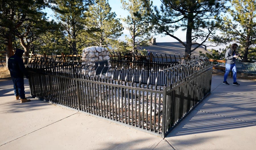 Visitors circle the fence at Buffalo Bill Cody’s gravesite on Lookout Mountain late Wednesday, Feb. 10, 2021, in Golden, Colo. (AP Photo/David Zalubowski)