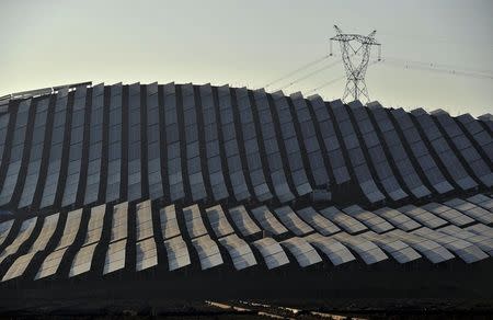 An electricity pylon is seen above a newly-built solar power plant on a hill during sunset in Wuhu, Anhui province in this January 2, 2015 file picture. REUTERS/Stringer/Files