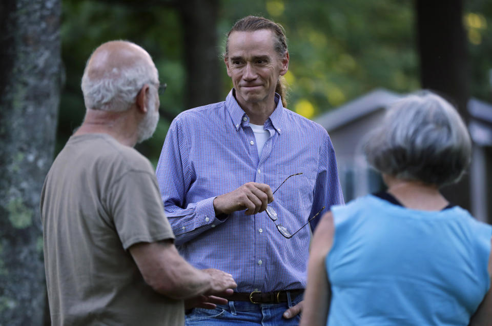 In this Thursday, Aug. 2, 2018 photo, State Rep. Kent Ackley, I-Monmouth, talks with constitutes Joel Packer, left, and Diane Clay, while campaigning in Litchfield, Maine. A national group that supports independent political candidates is pouring money into legislative races, raising alarm by critics who say so-called dark money is no longer limited to major political parties. (AP Photo/Robert F. Bukaty)