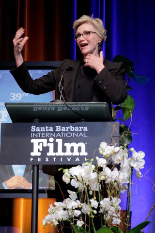 <p>Tibrina Hobson/Getty </p> Jane Lynch speaks at the Virtuosos Award in February 2024