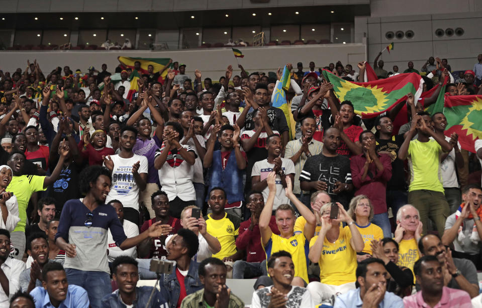 Spectators wave Ethiopian flags, top, and flags of the Oromo Liberation Front, right, at the World Athletics Championships in Doha, Qatar, Monday, Sept. 30, 2019. (AP Photo/Nariman El-Mofty)