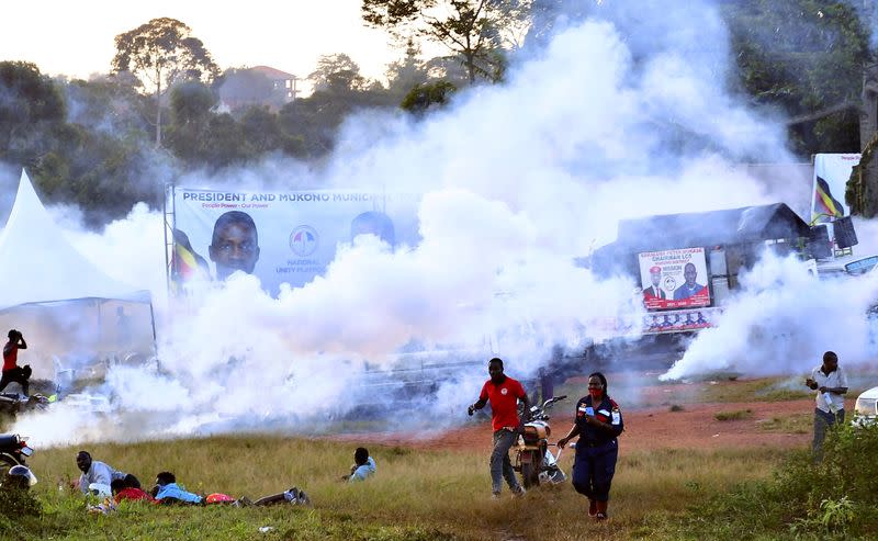 FILE PHOTO: People run away from tear gas as Ugandan pop star and presidential candidate Bobi Wine campaigns near Kampala