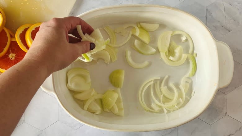 arranging sliced onion in dish