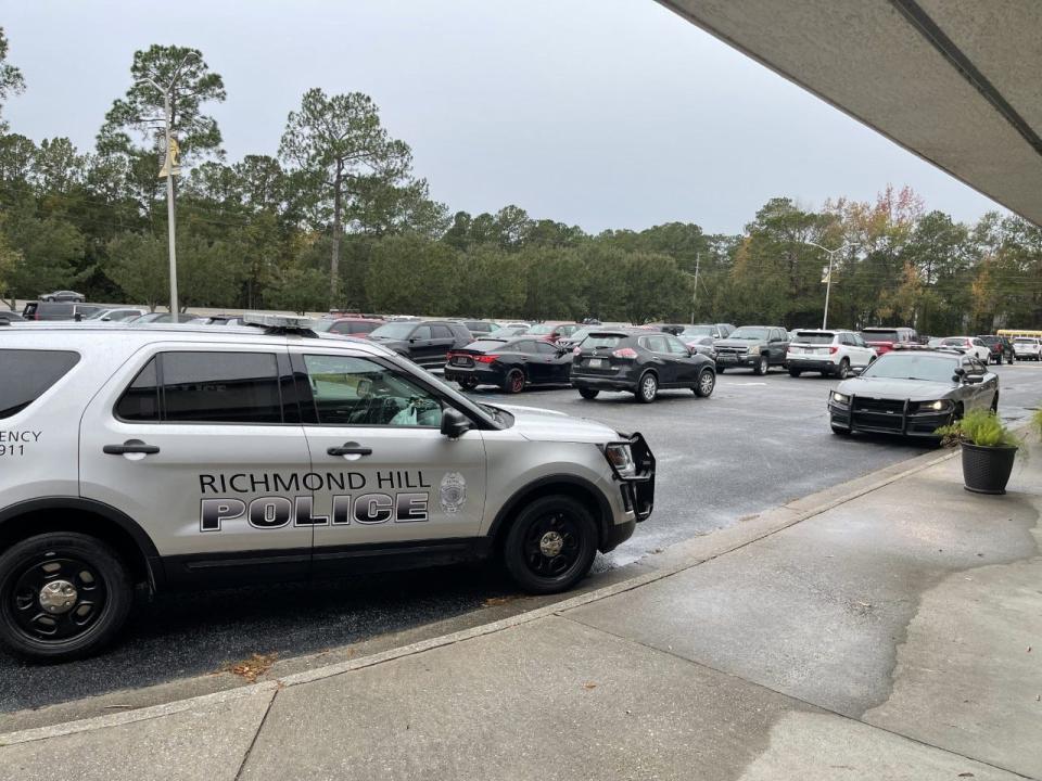 Police cruisers sit in front of Richmond Hill High School as a precautionary measure after several schools in Georgia reported what appears to be an active shooter hoax.