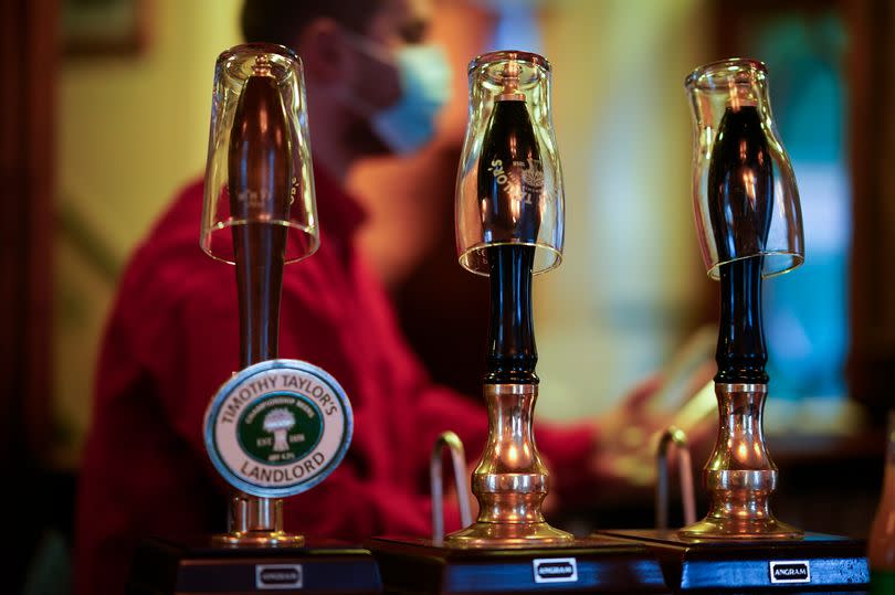 Empty pint glasses sit on the top of beer pumps