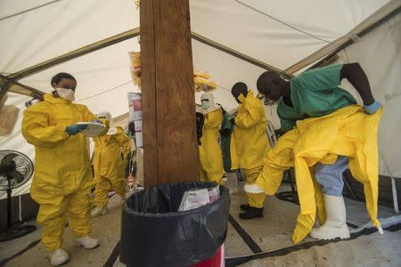 Medical staff working with Medecins sans Frontieres (MSF) put on their protective gear before entering an isolation area at the MSF Ebola treatment centre in Kailahun July 20, 2014. REUTERS/Tommy Trenchard