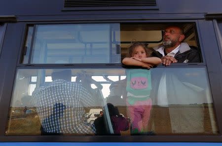 Migrants look out through the window of a bus near a collection point in Roszke village, Hungary September 9, 2015. REUTERS/Laszlo Balogh