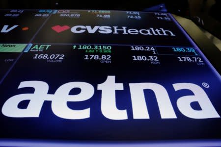 Logos of CVS and Aetna are displayed on a monitor above the floor of the New York Stock Exchange shortly after the opening bell in New York, U.S., December 5, 2017.  REUTERS/Lucas Jackson