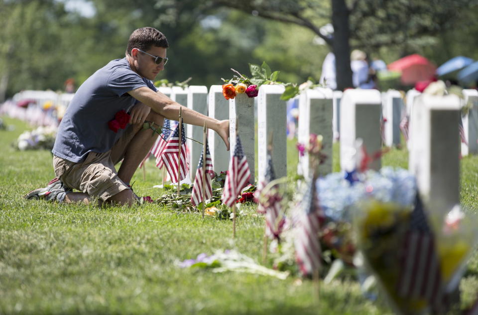 Ryan Buckingham of Camdenton, Missouri, touches the grave of his friend David Hortman during Memorial Day at Arlington National Cemetery in Arlington, Virginia, on May 25, 2015.