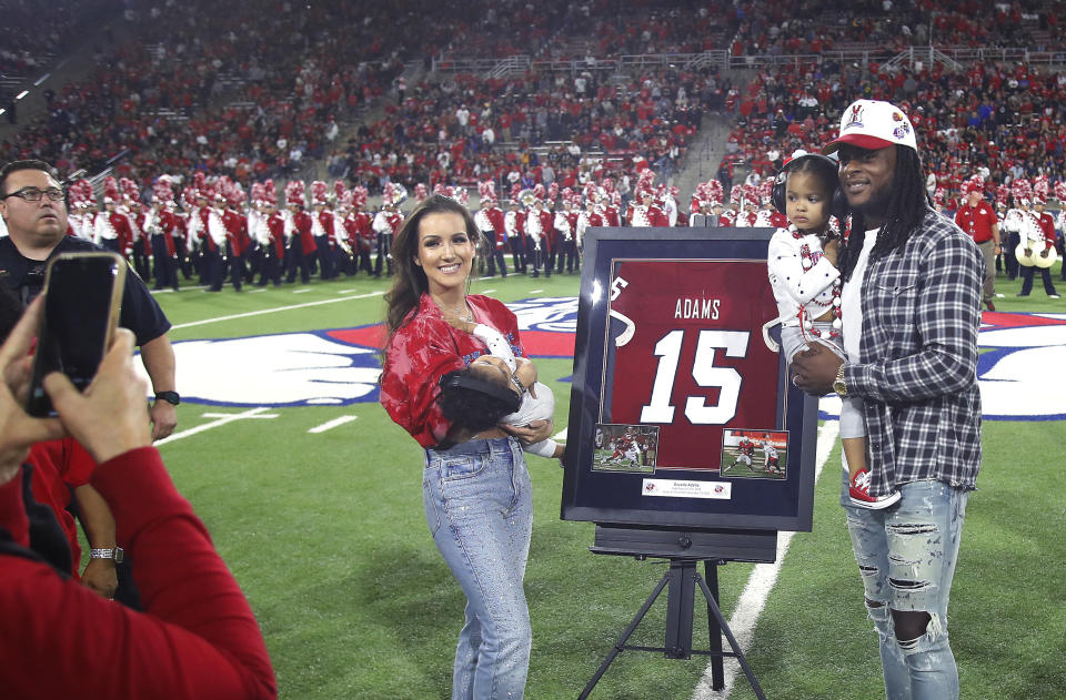 Las Vegas Raiders' Davante Adams, right, a former Fresno State player, has his jersey number retired at halftime of Fresno State's NCAA college football game against San Jose State in Fresno, Calif., Saturday, Oct. 15, 2022. (AP Photo/Gary Kazanjian)