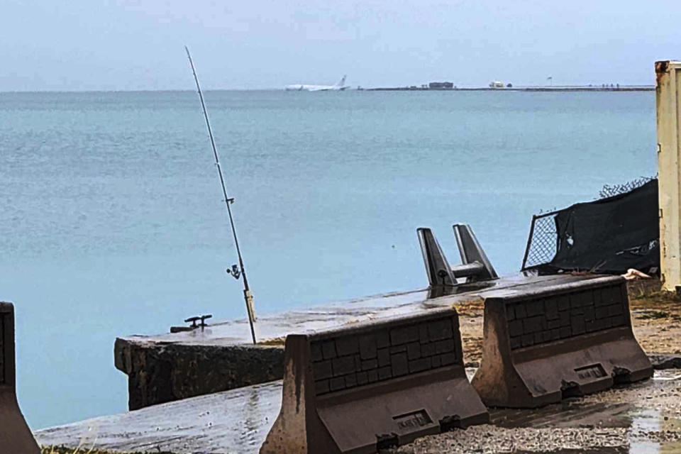 This photo provided by Diane Dircks shows a U.S. Navy plane that overshot a Marine base on Kaneohe Bay, Hawaii, Monday, Nov. 20, 2023. An official says all nine people aboard the plane have escaped injury. (Diane Dircks via AP)