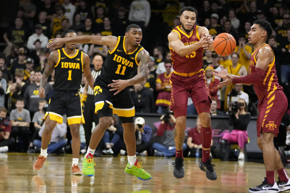 Iowa guard Tony Perkins (11) tries to steal the ball from Iowa State guard Jaren Holmes (13) during the second half of an NCAA college basketball game, Thursday, Dec. 8, 2022, in Iowa City, Iowa. (AP Photo/Charlie Neibergall)