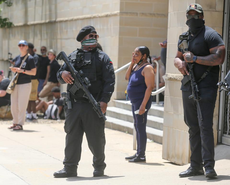 Armed protesters stand on South High Street on Sunday after viewing the bodycam footage of Jayland Walker's fatal shooting by Akron police.