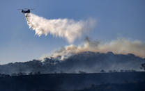 A helicopter drops retardant on the Silverado wildfire off Santiago Canyon Road where fierce winds have cause problems on Monday, Oct. 26, 2020, in Irvine, Calif. (Mindy Schauer/The Orange County Register via AP)